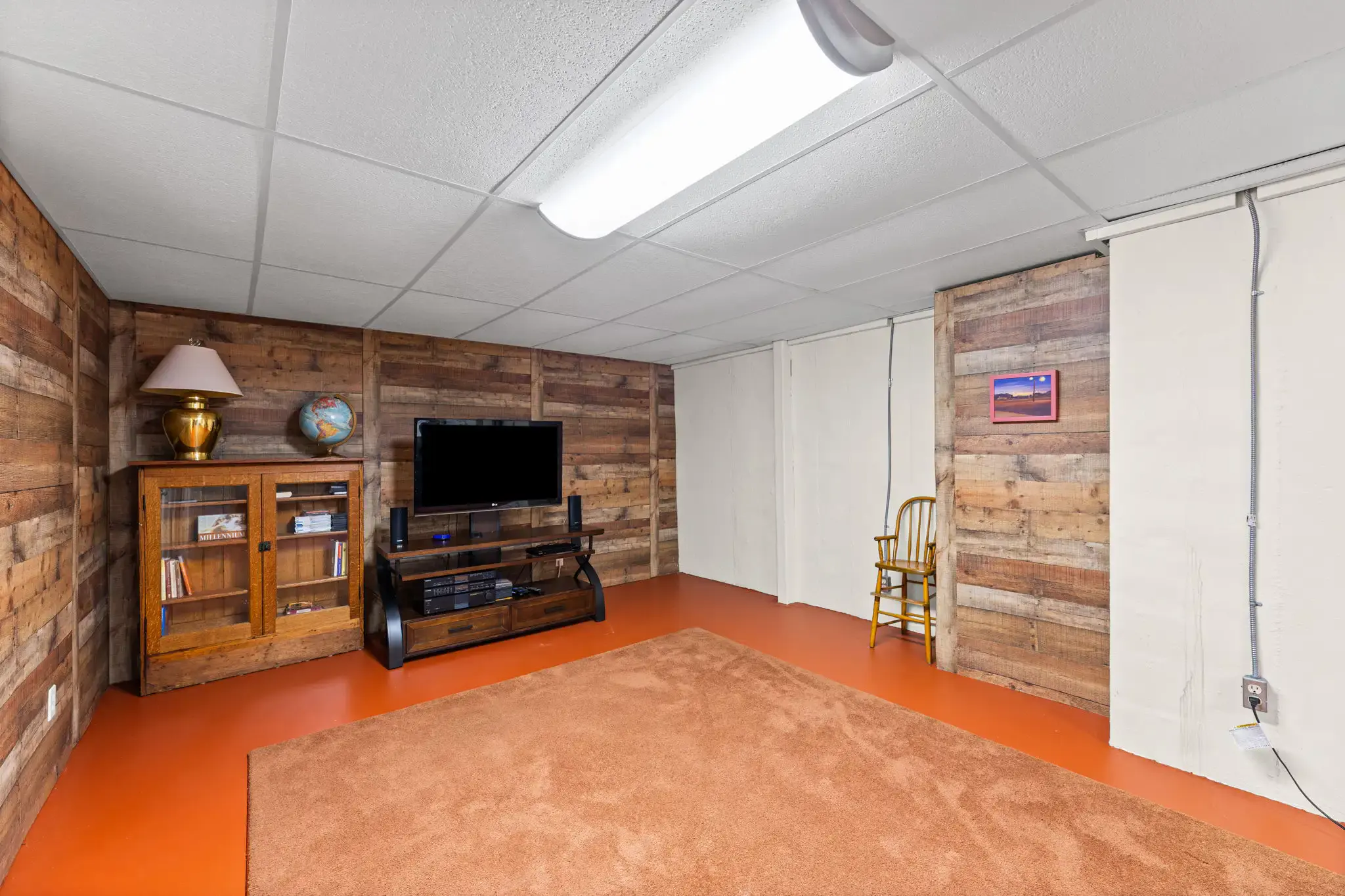 Lower level with wood plank accent walls and built-in storage closets
